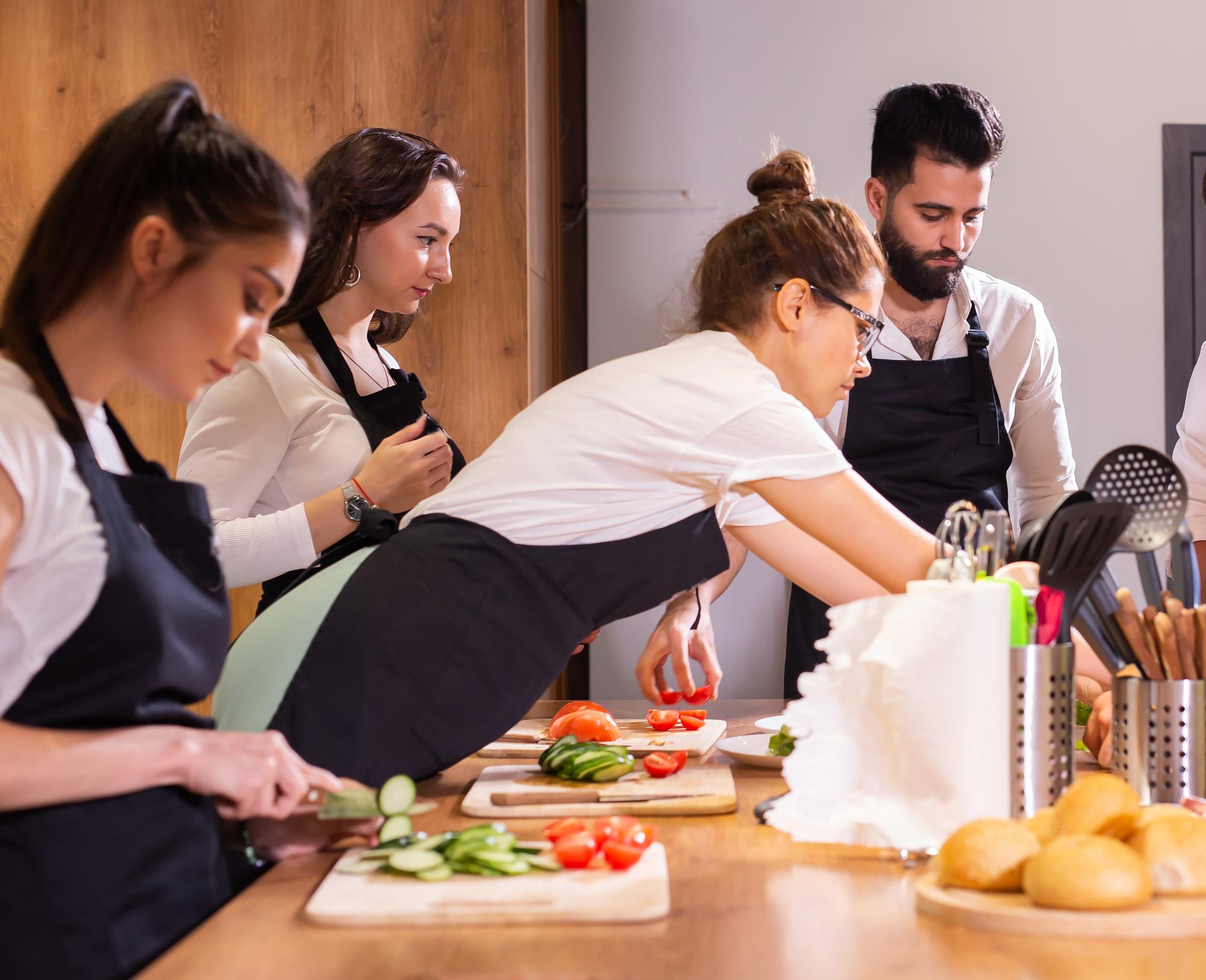 Açık mutfakta kurs katılımcıları çalışıyor